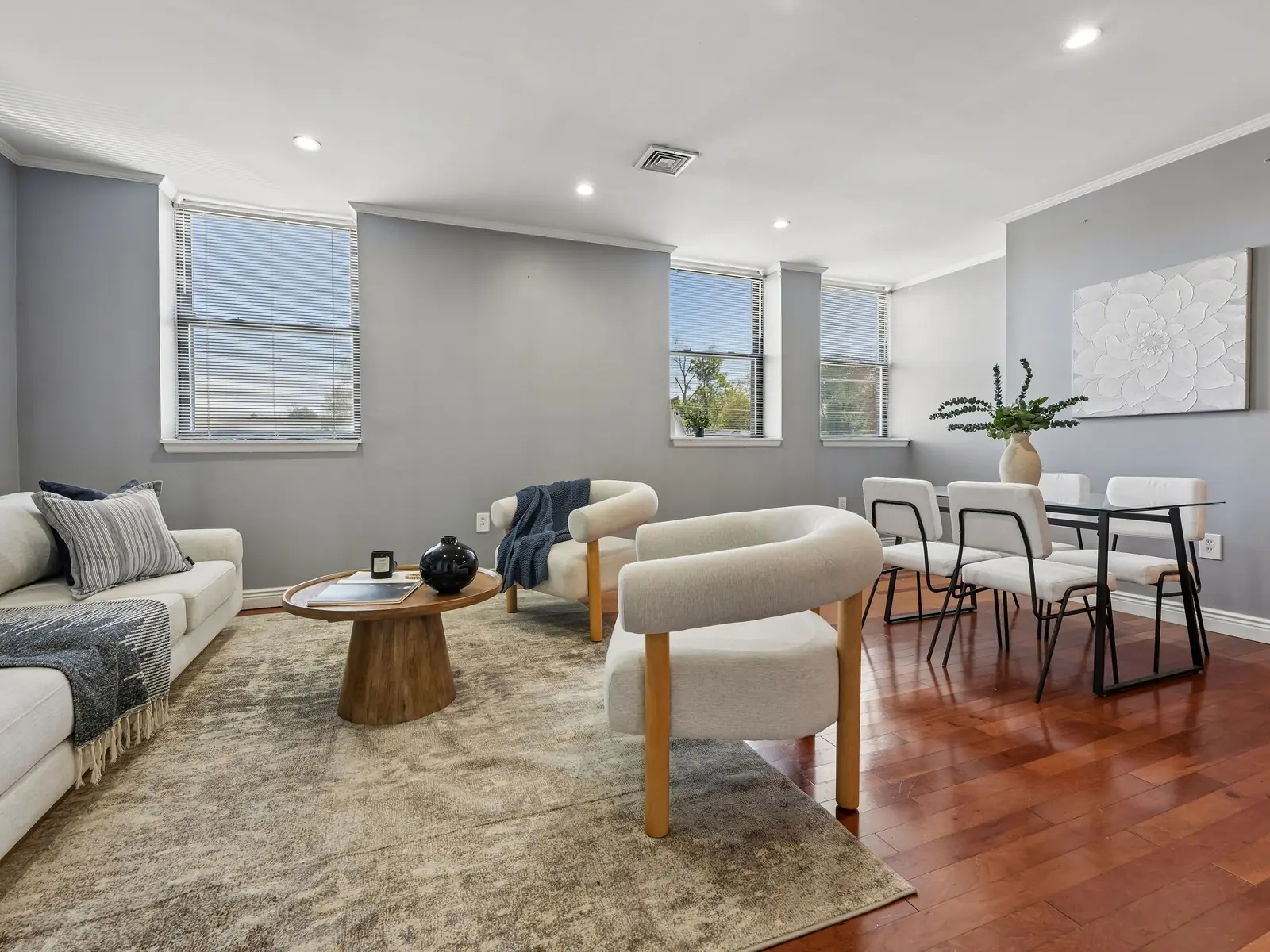 Renovated living and dining area at 124 East Main Apt 215 Denville with gray walls, hardwood floors, and natural light from corner windows