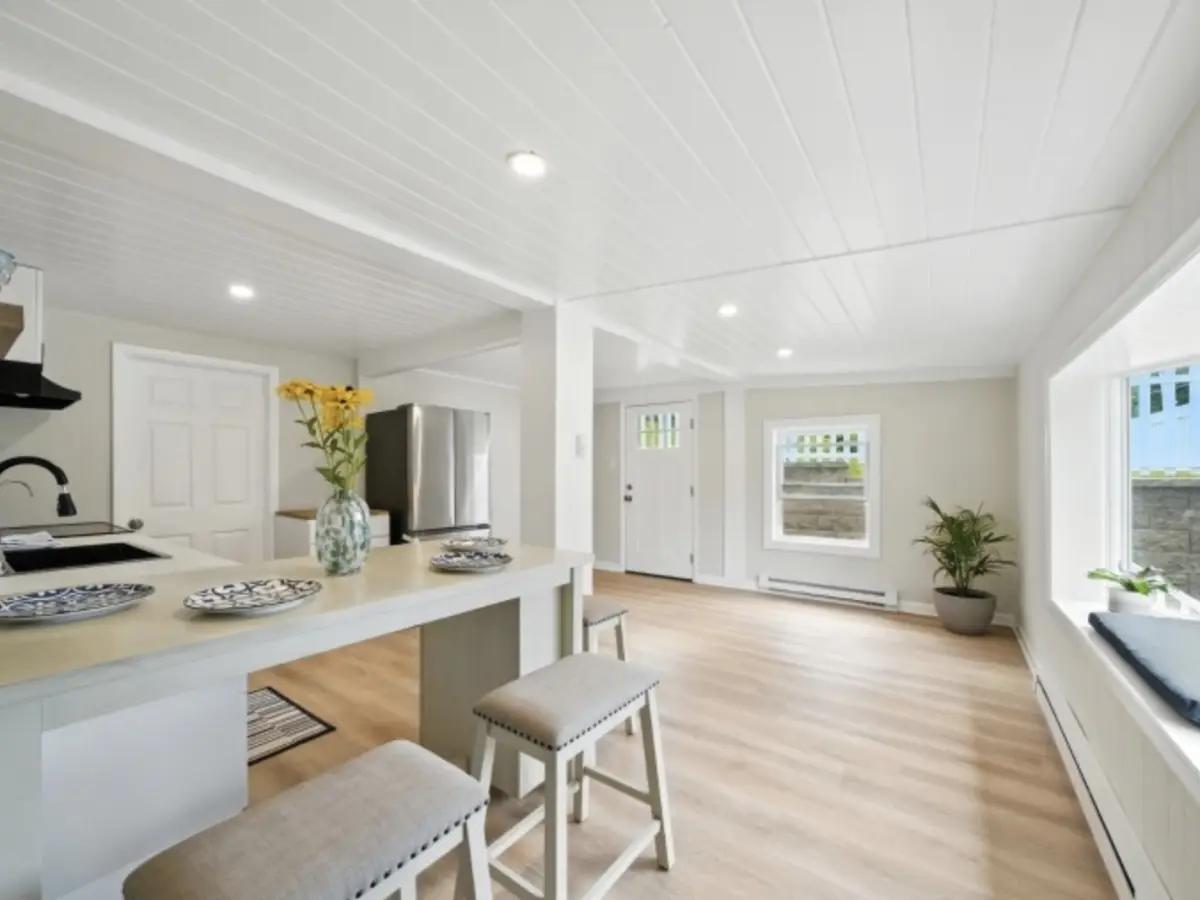 218 Maxim Drive, Hopatcong NJ — renovated lakestyle bungalow interior: open kitchen with white shiplap ceiling, stainless appliances, and light wood floors flowing to the front entry. Sold by BB Angjushev for $360,000.
